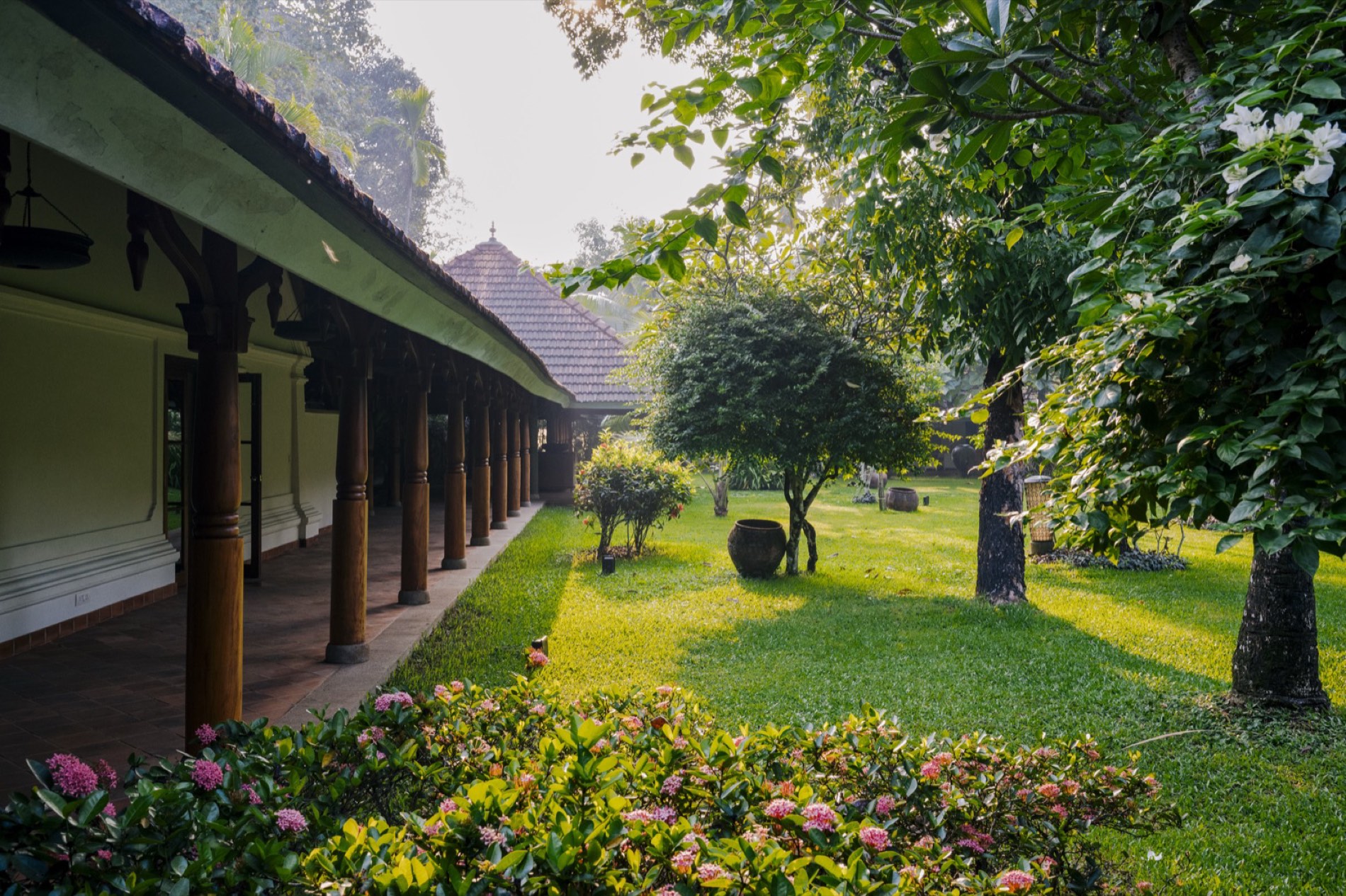 The long veranda beside the lawn and flowering beds of the Made Wijaya garden