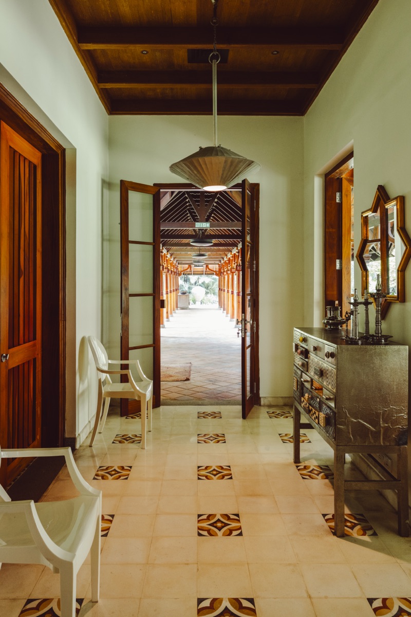 A hallway with patterned tiles and carved timber doors