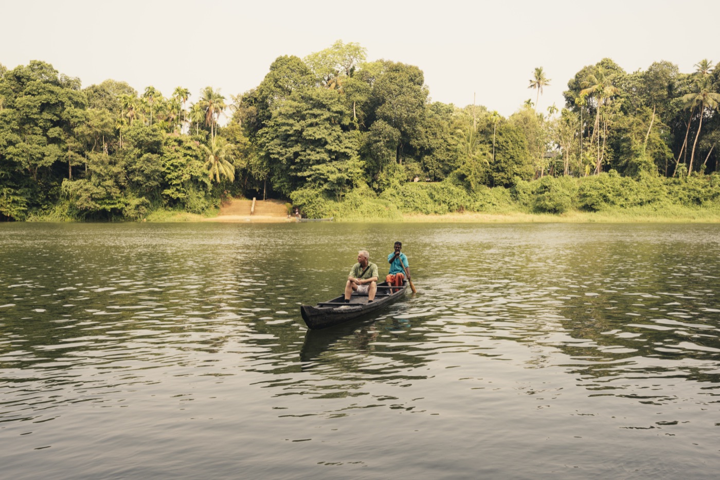 Two guests in a canoe on the river near the house